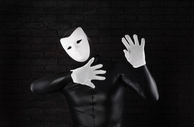 lustiger Pantomime in weißer Maske auf schwarzem Hintergrund