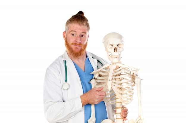 Lustiger rothaariger Arzt mit einem Skelett