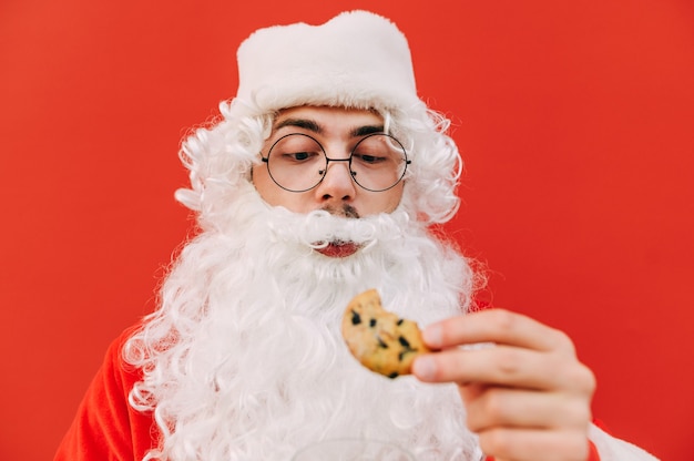 Lustiger Weihnachtsmann mit einem köstlichen Keks