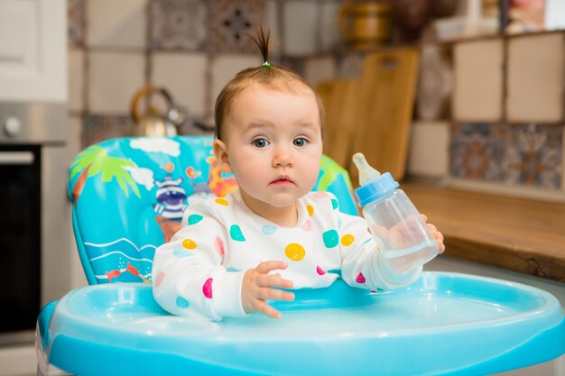 Lustiges Baby, das gesundes Essen auf Küche isst