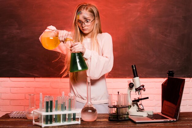 Lustiges chemisches Schulkind, das Experimente in der Laborexplosion in der Laborwissenschaft und -bildung durchführt