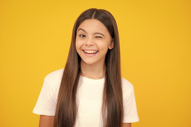 Lustiges Gesicht Teenager-Kind-Mädchen schließen ein Auge zwinkert und lächelt Menschliche Gesichtsgefühle Konzept Lustige zwinkernde Gesichtsgeste