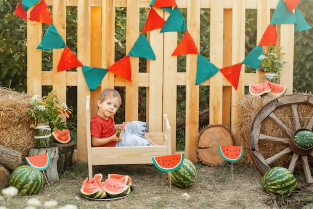 Lustiges glückliches Kind, das draußen Picknickzeit Wassermelone isst