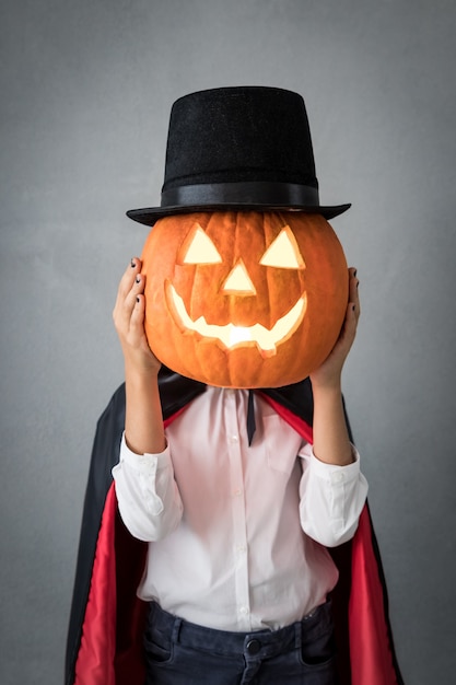 Lustiges Kind gekleidetes Halloween-Kostüm. Kind malte schrecklichen Vampir. Herbstferienkonzept