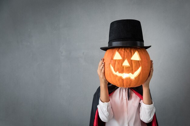 Foto lustiges kind gekleidetes halloween-kostüm. kind malte schrecklichen vampir. herbstferienkonzept