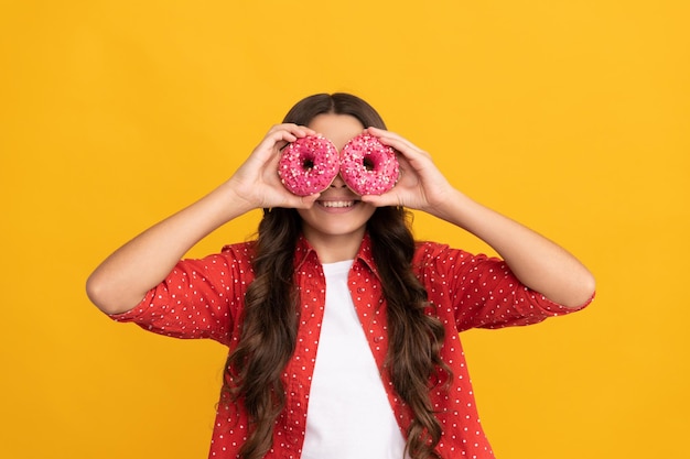 Lustiges Kind hält Donut-Bäckerei und Café-Kind mit glasiertem Donut-Kalorien-Essen und Dessert Donut-Bäckerei-Teenager-Mädchen, das Spaß hat, Backwaren, Naschkatzen, Kindheit, Glück, lecker