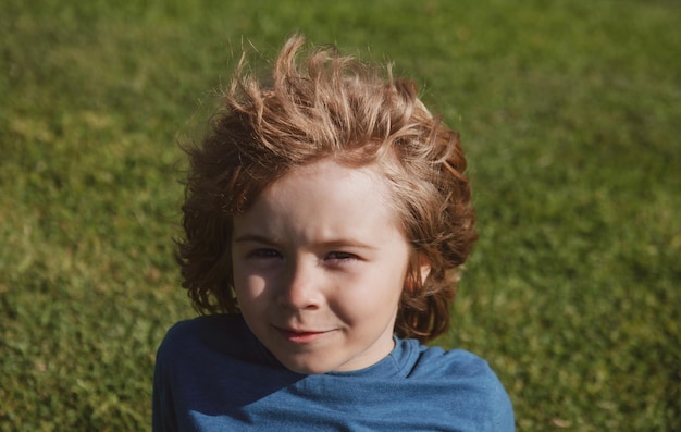 Lustiges Kindergesicht aus nächster Nähe Kinder auf Gras im Park Kopfporträt