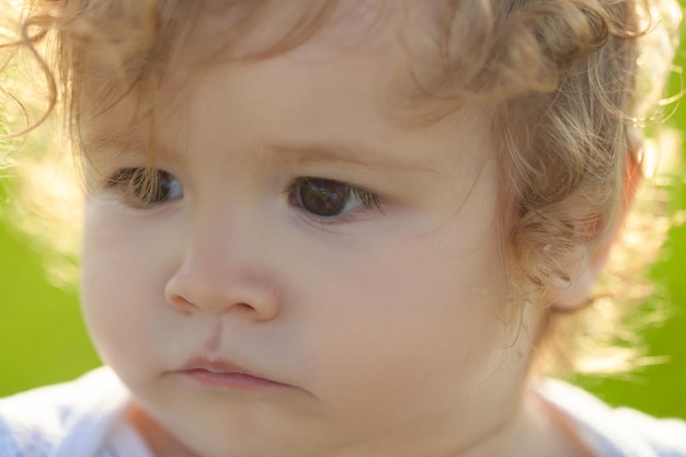 Lustiges Kindergesicht hautnah. Ernstes Porträt des Kinderbabys.