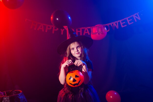 Lustiges Kindermädchen im Hexenkostüm für Halloween mit Kürbis Jack