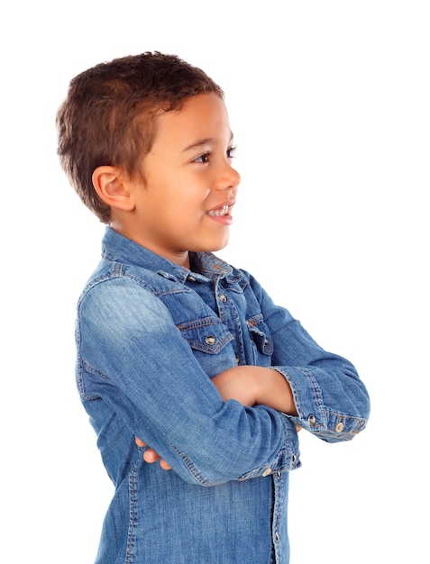 Lustiges kleines Kind mit dem dunklen Haar und den schwarzen Augen, die seine Arme kreuzen