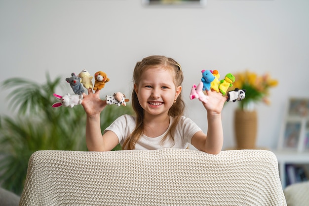 Lustiges kleines mädchen, das theater spielt. fingerpuppen sind auf kinderhänden gekleidet.