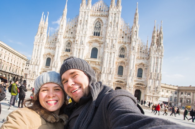 Lustiges Paar, das Selbstporträt auf dem Domplatz in Mailand im Winter macht, das Italien und die Beziehung reist