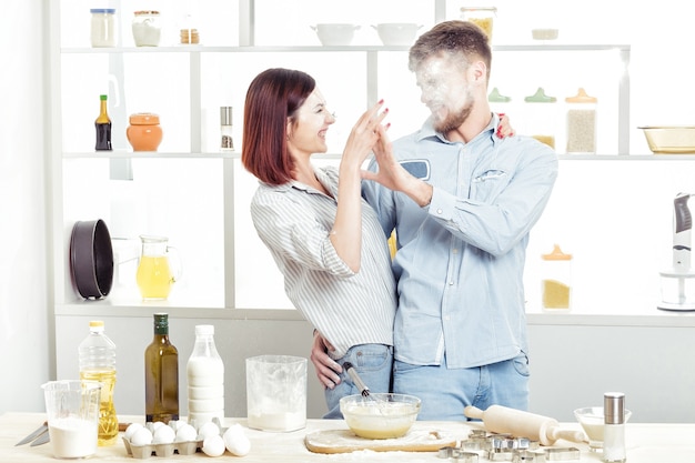 Lustiges Paar in der Liebe, Teig zu kochen und Spaß mit Mehl in der Küche zu haben