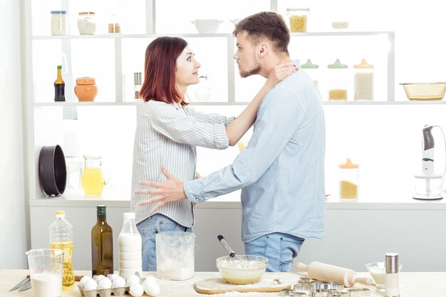 Lustiges Paar in der Liebe, Teig zu kochen und Spaß mit Mehl in der Küche zu haben