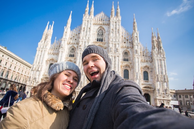 Lustiges Paar unter Selbstporträt auf dem Domplatz in Mailand. Winterreisen, Italien und Beziehungskonzept