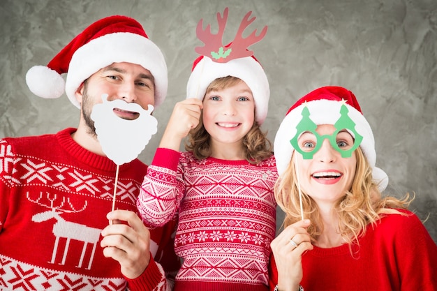 Lustiges Porträt der glücklichen Familie mit Weihnachtspapier-Requisiten