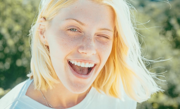 Foto lustiges verrücktes mädchen zwinkert einer schönen jungen frau mit sauberer, frischer haut und blonden haaren zu