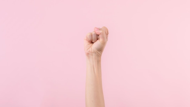 Foto luta de punho de mulher pelos direitos humanos e feminista com fundo rosa pastel conceito de força e coragem de igualdade de empoderamento feminino
