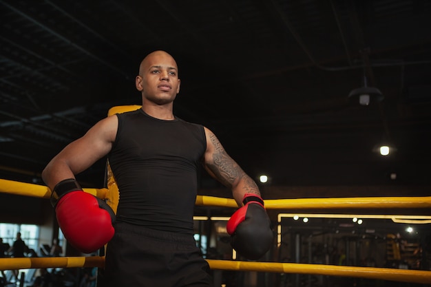 Lutador de boxe masculino africano bonito treinando na academia