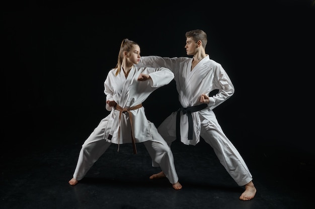 Lutadora de caratê no treinamento com o mestre, quimono branco. karateka em treino, artes marciais, luta