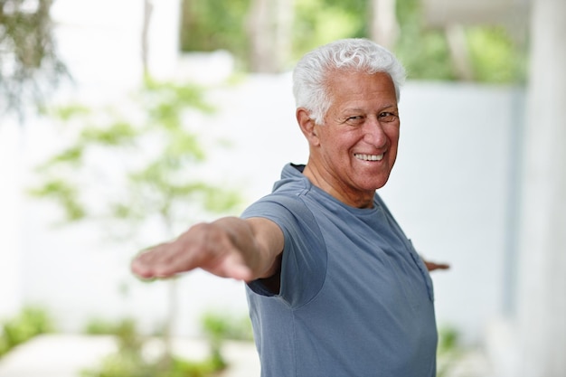 Lutando contra o processo de envelhecimento com ioga Retrato de um homem sênior fazendo ioga ao ar livre