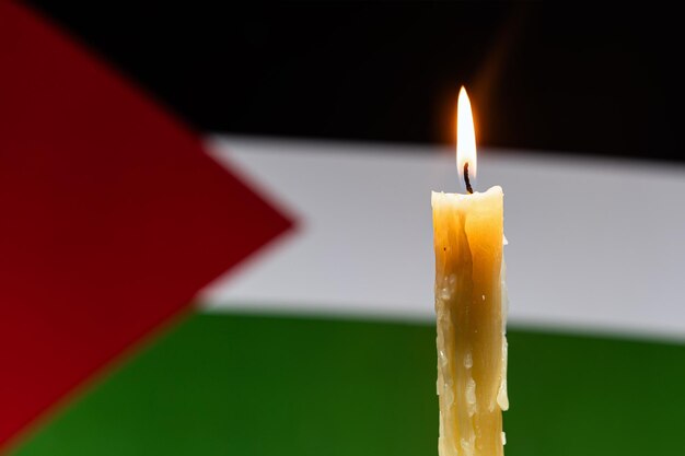 Luto no campo da Palestina na faixa de Gaza Uma vela ardente no fundo da bandeira palestina Vítimas de cataclismo ou conceito de guerra Luto nacional guerra no Oriente Médio