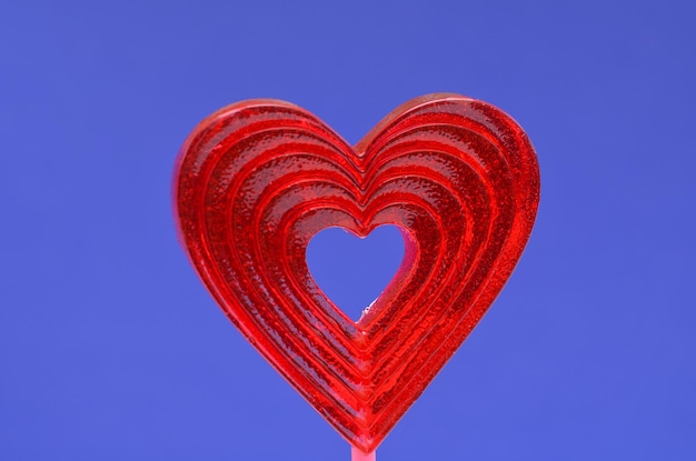 Lutscher in Form eines Herzens auf einer blauen Hintergrundnahaufnahme