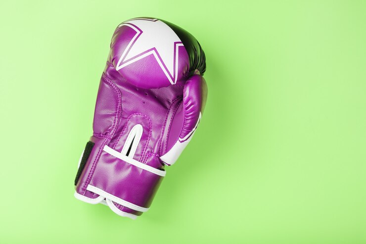 Foto luva de boxe rosa sobre fundo verde