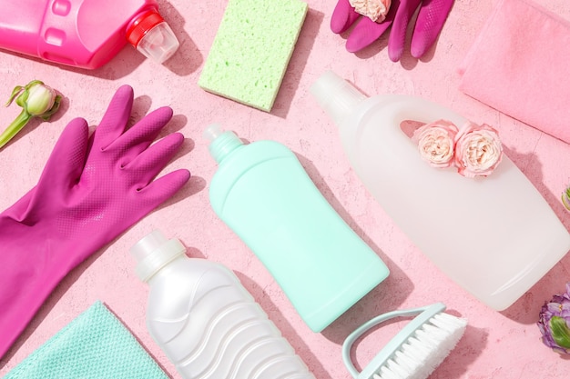Luvas de borracha com detergentes sobre um fundo rosa