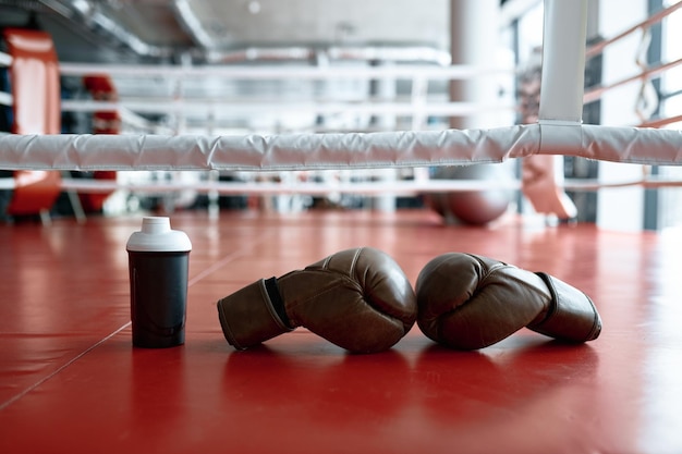 Luvas de boxe e garrafa de água no ringue