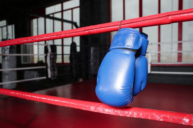 Luvas de boxe em cordas de ringue no ginásio