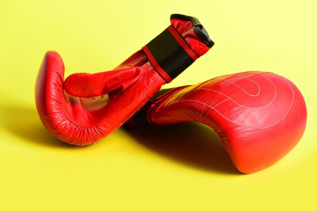 Luvas de boxe em vermelho isoladas em fundo amarelo