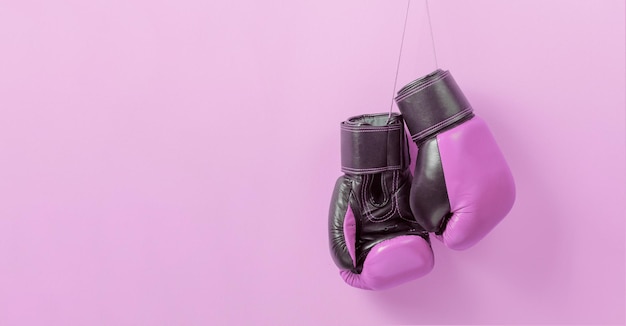 Luvas de boxe rosa em um fundo rosa símbolo da luta pelos direitos das mulheres e contra o câncer de mama modelo copiar espaço para maquete de texto