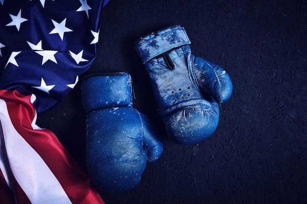Luvas de boxe velhas e a bandeira dos Estados Unidos da América no chão.