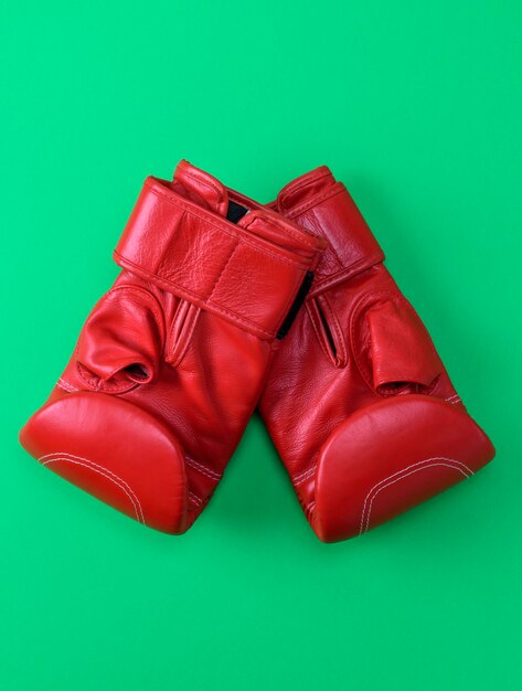 Foto luvas de boxe vermelhas contra fundo verde