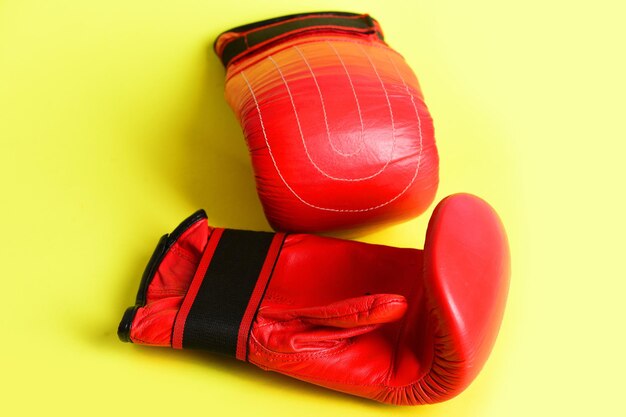Foto luvas para boxe na cor vermelha isoladas em fundo amarelo