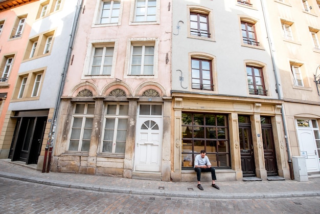 LUXEMBURGO, LUXEMBURGO - 18 de maio de 2017: vista na rua Munster com os edifícios antigos e o chef cozinheiro sentado com o telefone em Luxemburgo