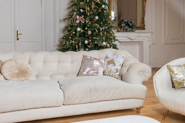 Luxuriöse, glänzende und klassische Kissen auf dem beigefarbenen Sofa, dekorative Pailletten- und beigefarbene Wildlederkissen auf der Couch, Dekoration des Zimmers für den Urlaub, Vorbereitung auf das neue Jahr und Weihnachten