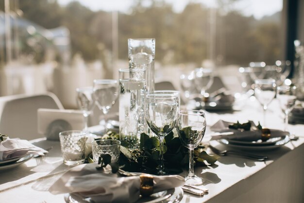 Luxuriöse Tischdekoration zum Essen in weißen Farben mit Blumen und Kerzen im Restaurant