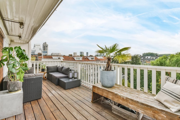 Luxuriöser Balkon mit grauem Sofa und Holzboden