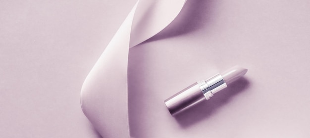 Luxuriöser Lippenstift und Seidenband auf errötendem violettem Urlaubshintergrund Make-up und Kosmetik-Flatlay für Produktdesign von Schönheitsmarken