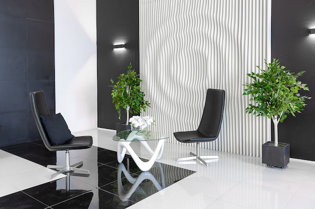 Luxuriöses futuristisches, trendiges, modernes Interieur in kontrastierenden Schwarz-Weiß-Farben mit interessanten modischen schwarzen Möbeln und dekorierter Wand