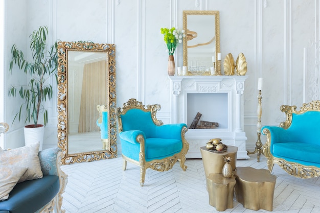 Luxuriöses helles Interieur des Wohnzimmers mit goldener Wand und schicken teuren Möbeln in den Farben Weiß und Gold