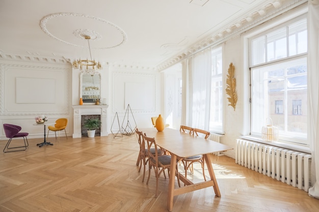 Luxuriöses Interieur einer geräumigen Wohnung in einem alten historischen Haus aus dem 19. Jahrhundert mit modernen Möbeln. hohe Decke und Wände sind mit Stuck verziert
