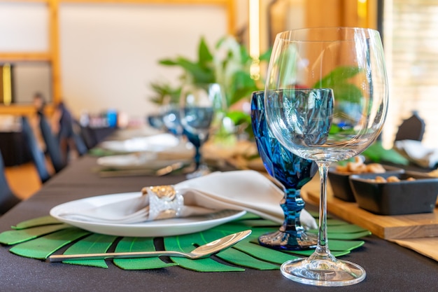 Luxuriöses Mittag- oder Abendessen auf dem langen Tischmuster mit einem schwarzen Tisch mit Blumendekor.