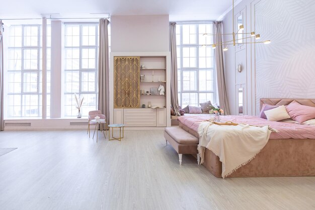 Luxuriöses, modernes Schlafzimmer-Interieur einer teuren, geräumigen, hellen, stilvollen Wohnung. Polstermöbel und dekorative Beleuchtung, sanfte Pastellfarben und gemütliche Atmosphäre