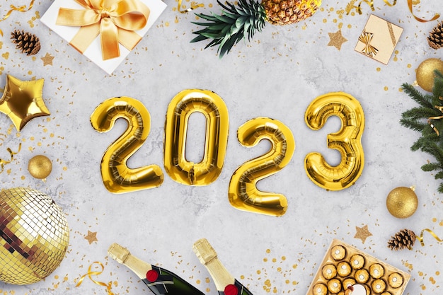 Luxus Neujahr 2023 Party Goldene Luftballons 2023 liegen auf grauem Hintergrund mit goldener Spiegelkugel Süßigkeiten Champagner Geschenke Ananas Weihnachtsbaum und Süßigkeiten Draufsicht Feiertagsfeiern