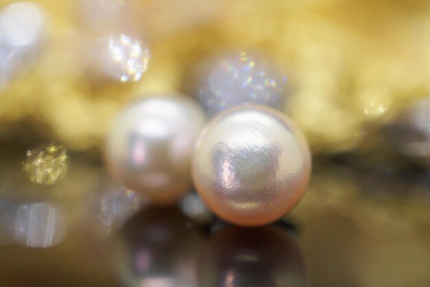 Luxus-Perlenohrrringe mit Reflexion auf golden-schwarzem Hintergrund