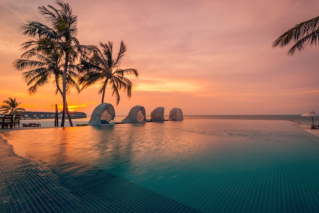 Luxus-Pool-Sonnenuntergang, Palmensilhouette mit windiger Infinity-Pool-Wasseroberfläche. Sommerurlaub
