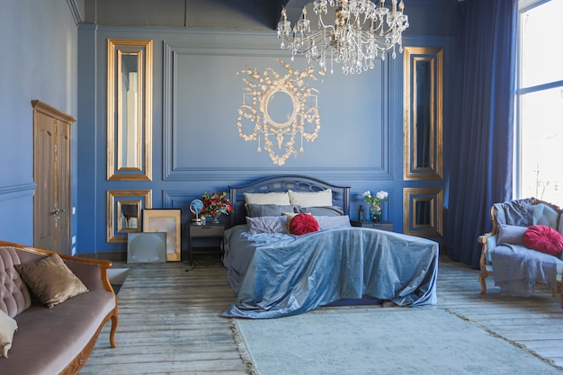 Luxus-Schlafzimmer-Interieur in tiefblauer Farbe mit antiken teuren Möbeln und goldenen Elementen im Barockstil